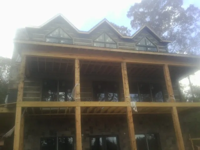 Dormers and porch framing on a large log home under construction — Roof Coating work by our crew in Wood Dale