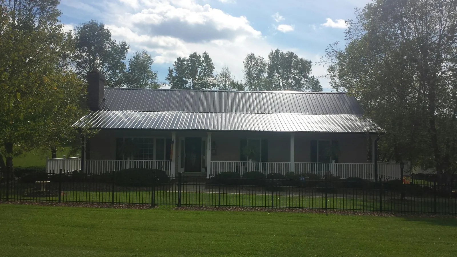Gray metal roof on a brick ranch with a full width front porch — Gutter Guard Installation work by our crew in Wood Dale